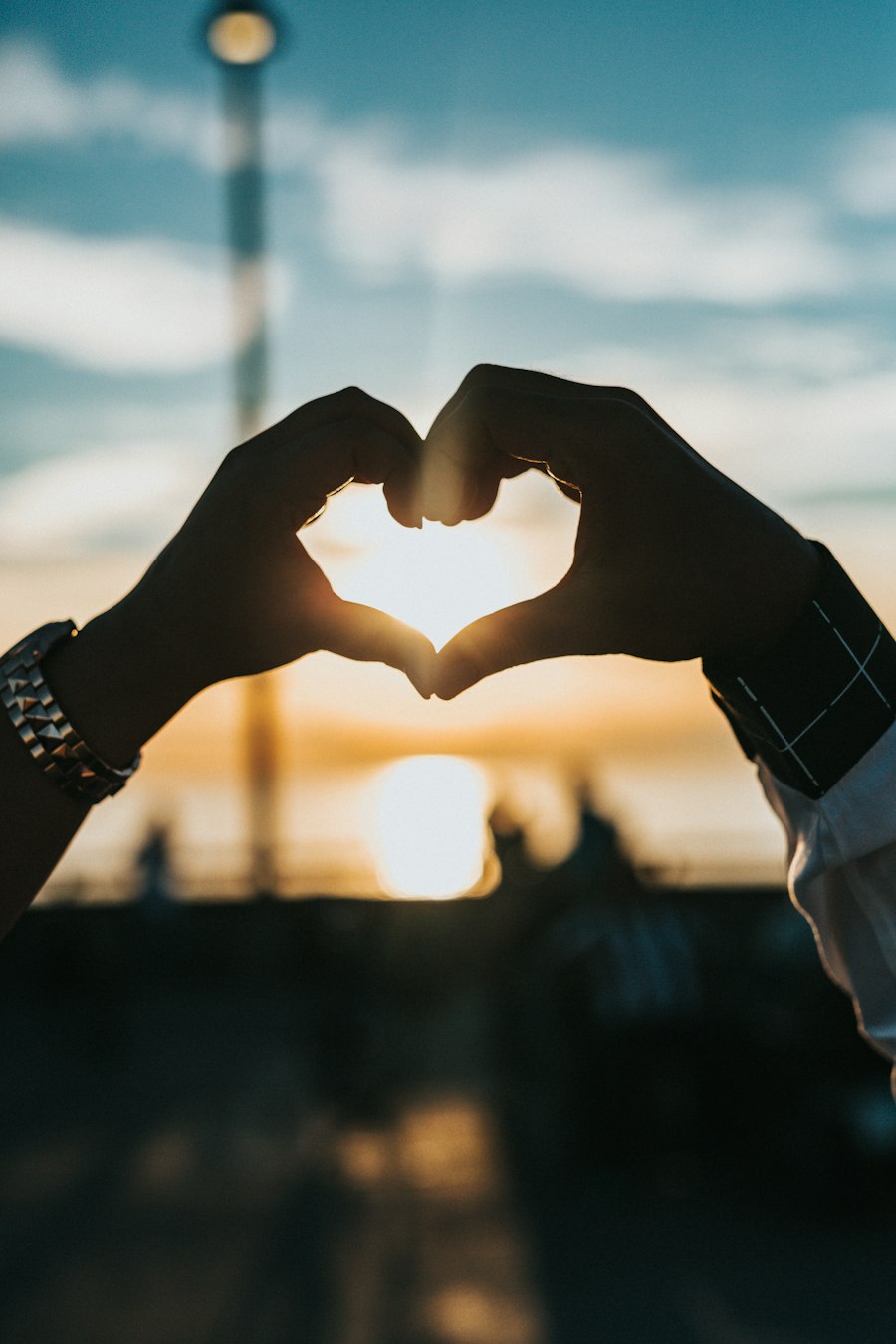 Hands forming a heart shape in the sunlight